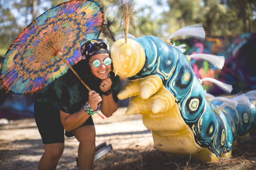 Hulaween patron posing with caterpillar statue installment at hulaween, Patrick Hughes